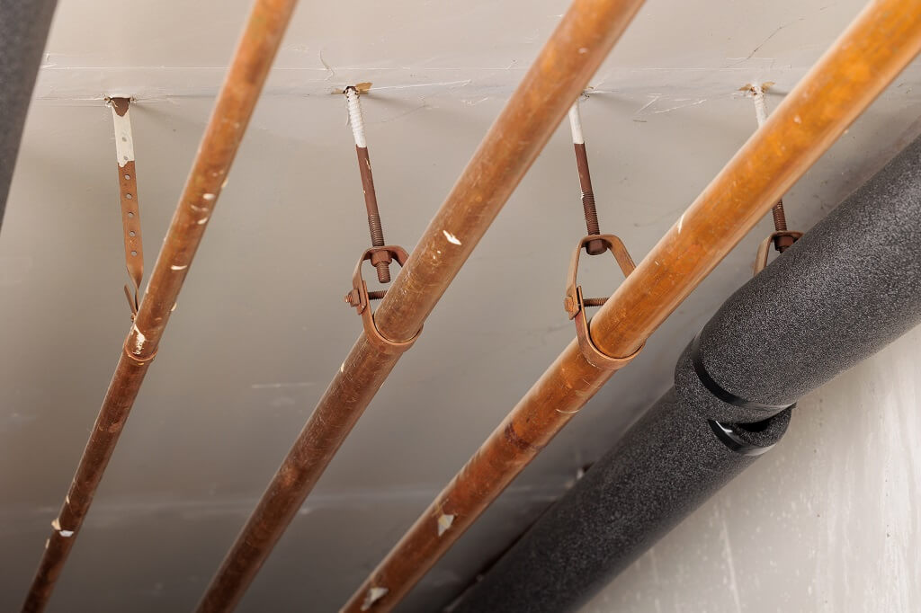 Bakarne cevi za grejanje postavljene na plafonu sa nosačima